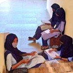 ヒジャーブを身に着けているイスラム教徒の学生は、大学の階段、廊下、ポーチの厳しい寒さの中で地面に座って勉強しています。